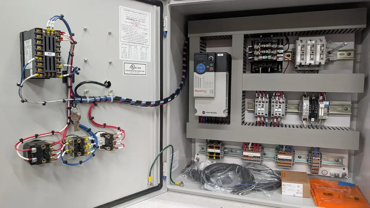 Custom process control panels with the enclosure doors open during a panel build